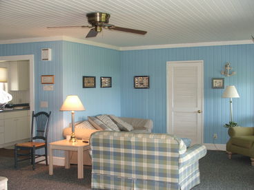 The open concept bright living room gives a Cape Cod feel to the interior of the main cottage.  Cozy couches, over sized chairs and comfortable lighting offer a great spot to sit and read a great summer book.