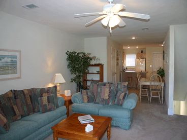 View of living room toward dining area and kitchen.  Sofa is a queen sleeper.