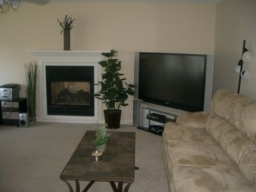Fireplace with 47\' TV, queen sleep sofa, plus another sleep sofa and coffee table, a recliner and stereo.