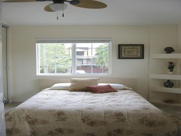 Bbedroom with queen bed and ceiling fan above.  not shown is the dresser and tv/dvd combo on the opposite wall