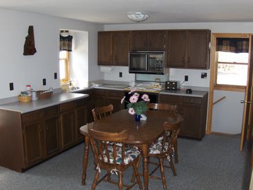 Kitchen entirely outfitted with a range, microwave, coffee maker, large refrigerator and a sink all for your use. A table with four chairs is yours for when you are eating in. All pots, pans, dishes, silverware and assorted glasses and cups are in the cabinets as well.