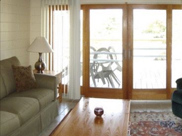 Very nice living room offers a queen size sleeper sofa and access to the shared deck which takes you down to the sand.