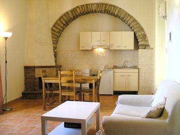 Open Living/Dining Area with vaulted ceiling, fireplace and origional stone-work.