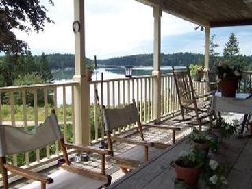 Very large roofed porch has a dining area at one end seating at the other