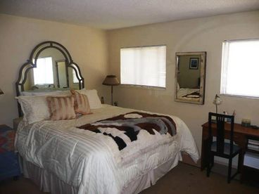 Master bedroom,  w/ king bed and windows look out to ocean
