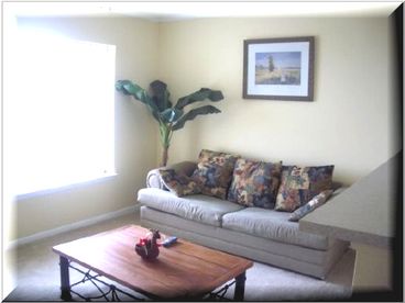 Living room with window that has the view of the ocean. This picture does not do justice. The couches are new and there have been changes made to living room.