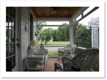 Relaxing screened-in porch with ceiling fan. 