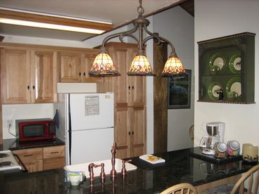 The kitchen was recently remodeled in June 2007, with rich green countertops and cabinets that mimic the outdoors.  The woodsy effect is further complimented by the twig/leave door pulls throughout.   