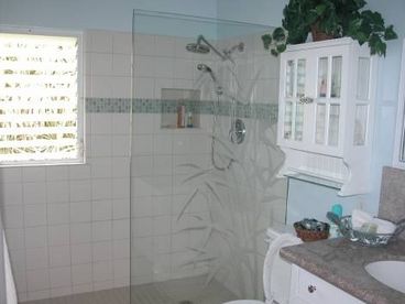 Enjoy a large, walk-in shower with an etched glass enclosure.