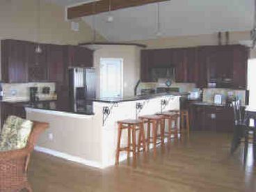 The spacious, fully equipped kitchen has a dining table that seats 8 and 4 more at the bar.