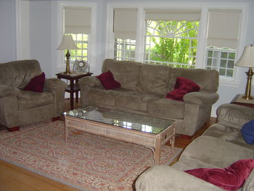 Large living room with two couches and an oversized chair, tv/cable/dvd, non-working fireplace.