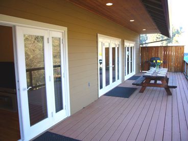 Back deck with 2 picnic tables and gas grill. 