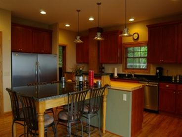 Granite and butcher block counter tops, full size fridge/freezer, stainless steel appliances, wine cooler, hardwood floors