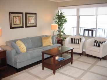 Living room with sleeper sofa and large windows overlooking the ocean.