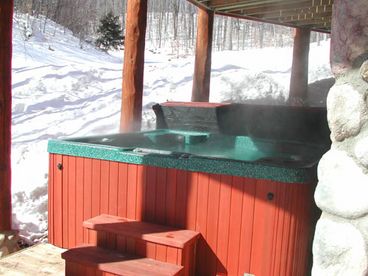 hot tub in winter with ski hill in background