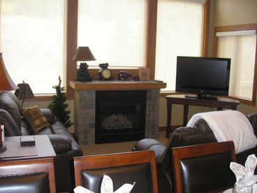 Cozy living room with fireplace and fabulous views of the mountains and trees