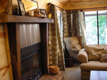 View of the wood burning fireplace and wrap around windows.