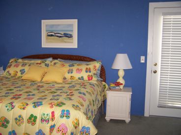  Large Master Bedroom with King Bed & door to balcony with chairs, has a comfy chair to sit and read quietly if you wish and a TV, there are games in the side table