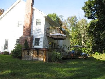 The Hot Tub and Large Wrap Around Deck that features 3 separate eating areas, as well as the Master Bedroom Balcony are seen in this side/rear view of the house.