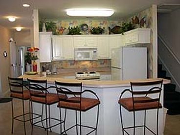 Kitchen with bar open to living room and dining room