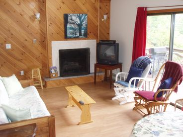 Living room with fireplace, sliding glass doors lead out to large deck with great views