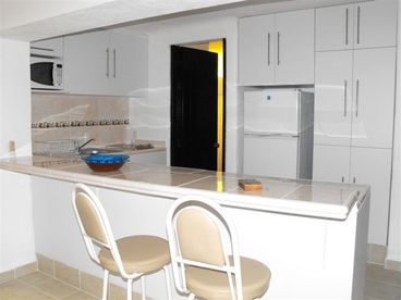 Full size kitchen with new fridge, microwave, sink, and ceramic cook top.