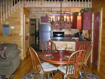 Dining room and kitchen with modern stainless steel appliances.