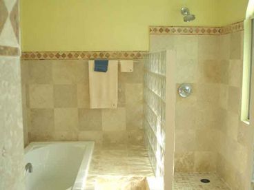 Stone, custom tile, and onyx in the master bath with tub and shower