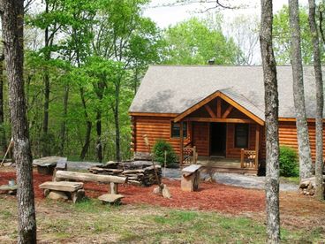Entrance to Dogwood lodge with large firepit and bench seats