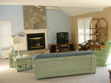 Cathedral ceiling in den features natural stone fireplace with gas logs; den opens to large front deck. 