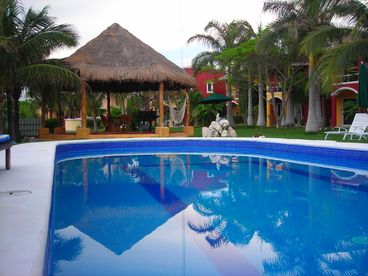 A large pool with a palapa and a grill for your enjoyment.