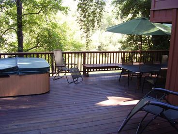The large river view deck has a hot tub, dining and lounging furniture.