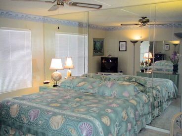 The bedroom features a king-sized bed and beautiful linens with a shell theme. Big windows let in natural light, while a 27 inch TV and DVD player provide entertainment. 

