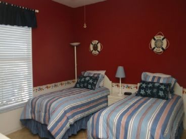 Sail away to dreamland in this handsome red, white and blue twin room with ceiling fan, large closet and shared full bath decorated in a seashell motif.