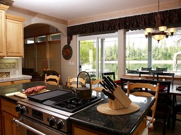 Fully stocked kitchen includes indoor grill, two refrigerators and additional oversized freezer, contemporary appliances and ample counter space. Breakfast Bar dining for four at impressive granite island. Striking copper pounded dining table and accompanying leather chairs seats six with panoramic water vistas.