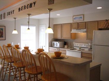 Kitchen is fully stocked with pots, pans, dishes, cooking untensils, toaster and coffee pot.