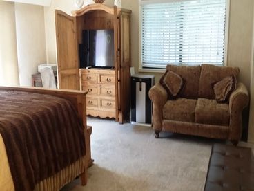 This is the Master Bedroom from a different view showing the Large Flat Screen TV, seating, and tot he left is the sliding glass door shown in the picture above