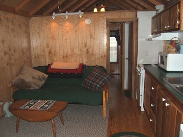 The main room features a furnished kitchen, full-size futon, and dining area (not shown)