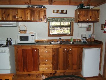 The furnished kitchen includes a stove, fridge, microwave, 2 coffee makers, dishes, pots, pans, and utensils.