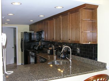 Remodeled kitchen with stone counter tops and breakfast bar