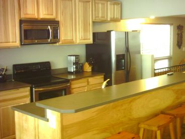 A brand new kitchen complete with stainless steel appliances and a flat screen TV.