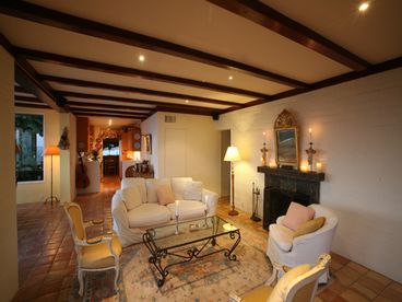 Living room with beamed ceiling, fireplace, large screen TV, surround sound system