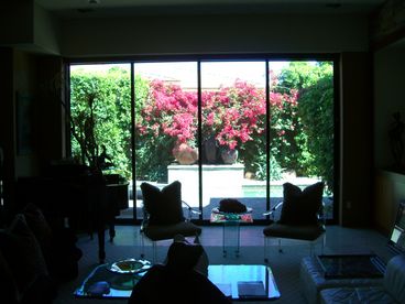 View from front entryway, through living room, to backyard pool and water sheer - 10 foot doors roll completely back into one unit for indoor/outdoor living