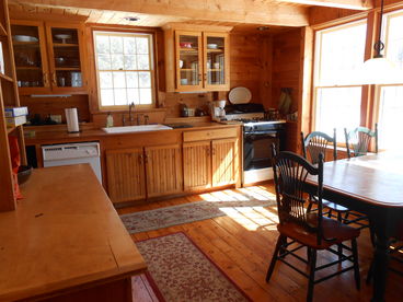 Kitchen with white porcelain dishes, table with leaf seats 8; dishwasher, microwave, gas range, copper fixtures, huge farmer\'s sink, wine cooler.