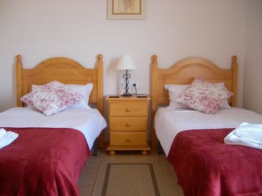 Twin bedroom with private balcony with views of the sea, swimming pool and gardens