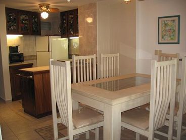 This is the dining room table area and kitchen area in background.  Stain glass in cabinets in kitchen.