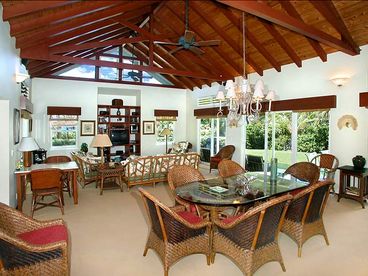 The huge living area has seating for six at the entertainment center to enjoy the TV, DVD player, or CD stereo.  The dining table seats six or eight.  Five sliding doors open to the surrounding lanai and lawn.