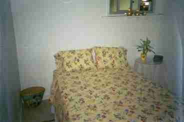 a fuul size bed  with a little night stand and a large walk in closet.