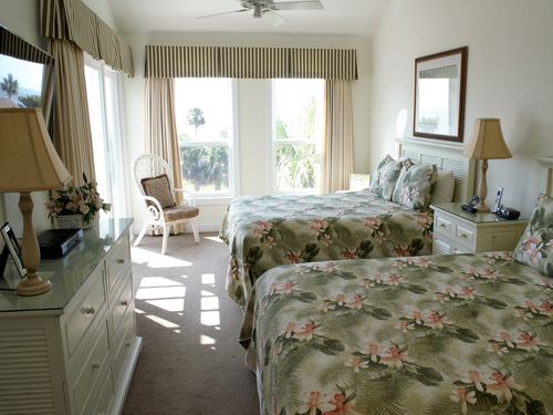 The master bedroom has two queen size beds.  The beds have views of the ocean and the bedroom has access to the deck.  The room has a double dresser and 55 in. high definition tv.  A full shower bath adjoins the bedroom