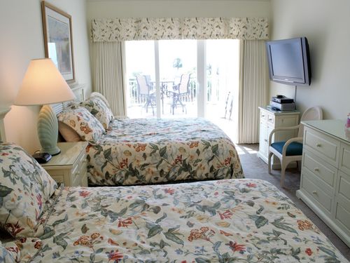 The second/guest bedroom has two queen size beds.  The beds have views of the ocean and the bedroom has access to the deck.  The room has a double dresser and 55 in. high definition tv.  A full tub bath adjoins the bedroom